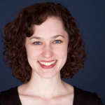 photo of girl with curly brown hair in front of blue background