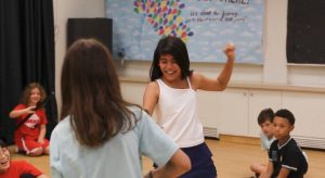 Students with huge smiles laugh as they fight against each other using plastic weapons.