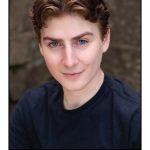 eli-schulman-copy A boy with short brown hair wearing a navy sweater.