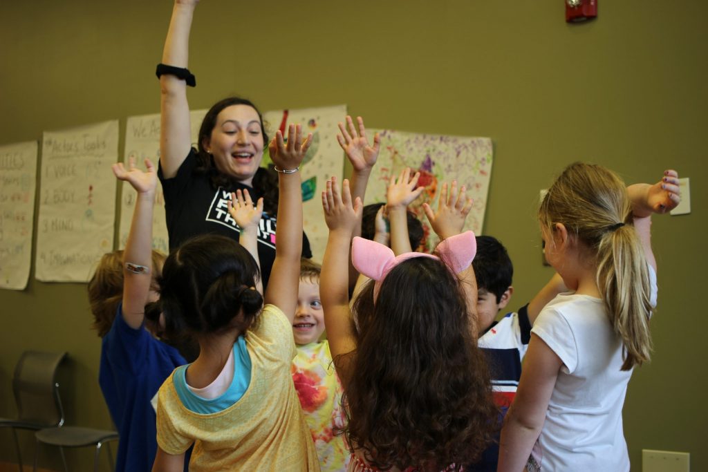 WFT Teaching Artist Wheelock Family Theatre teaching artist surrounded by students.