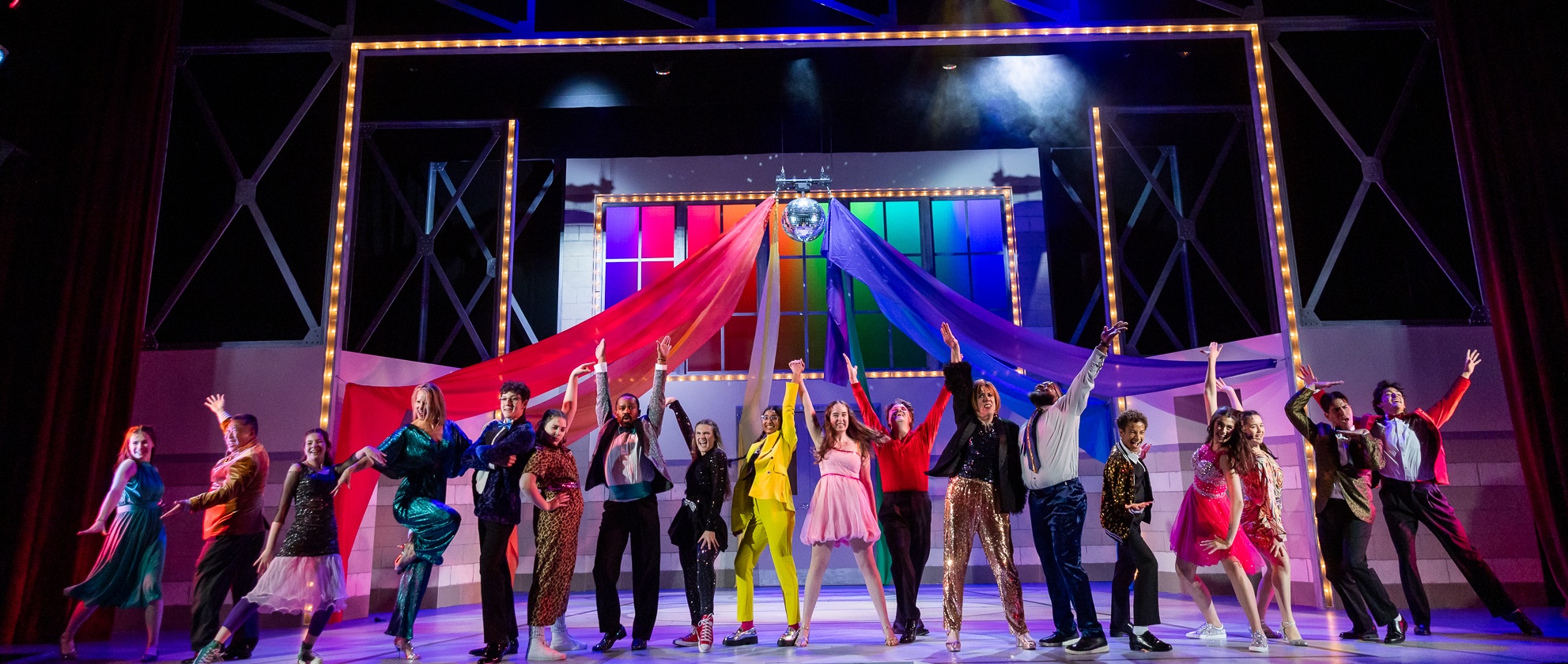 the-prom-careers-banner Performers stand in a line, dressed in festive formal wear in a dramatic joyful pose.